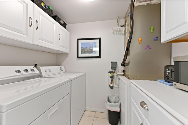 laundry room featuring cabinets, light tile patterned flooring, and independent washer and dryer