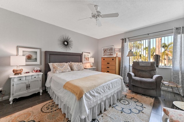 bedroom featuring dark hardwood / wood-style flooring, a textured ceiling, and ceiling fan