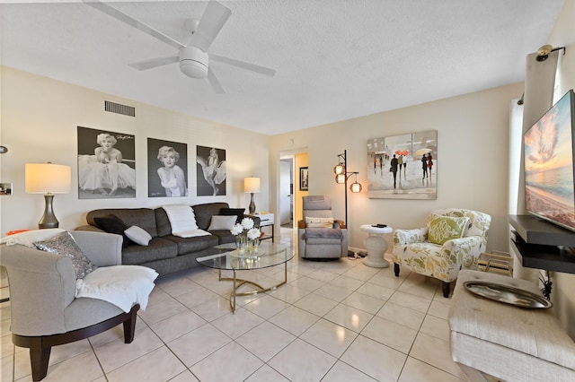 tiled living room featuring ceiling fan and a textured ceiling