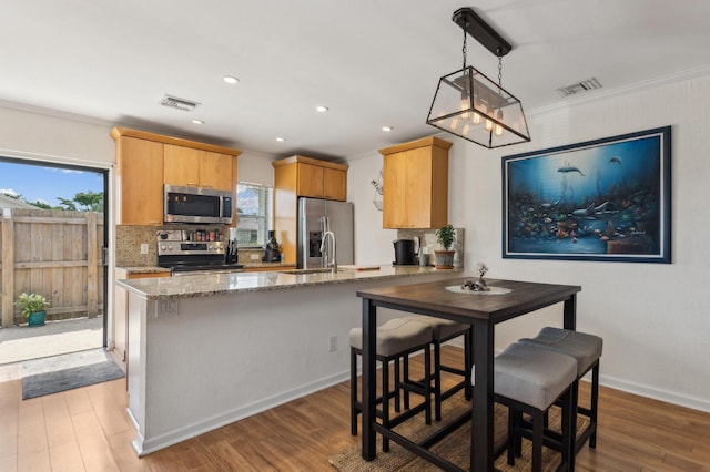 kitchen featuring stainless steel appliances, a peninsula, visible vents, decorative backsplash, and crown molding