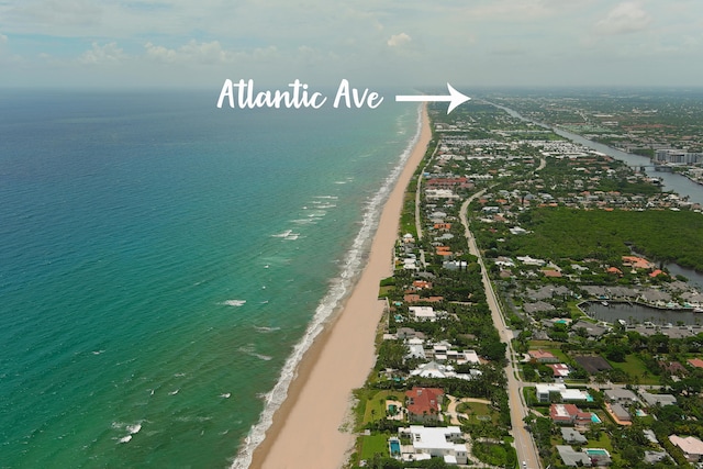 birds eye view of property featuring a water view and a beach view