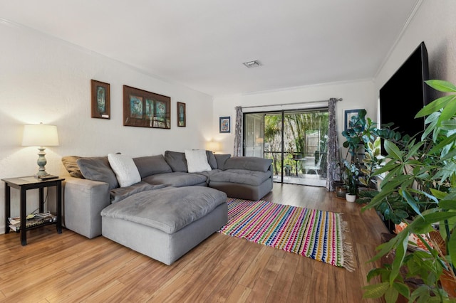 living room with ornamental molding and wood finished floors