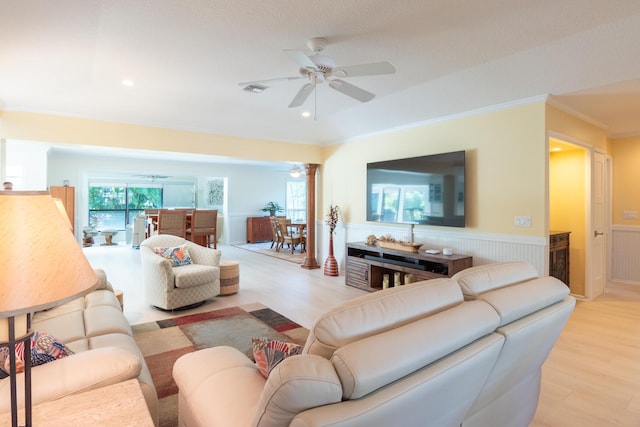 living room featuring ceiling fan, ornamental molding, light hardwood / wood-style flooring, and ornate columns