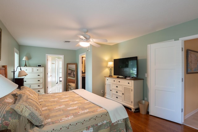 bedroom featuring ceiling fan, dark hardwood / wood-style flooring, and ensuite bath