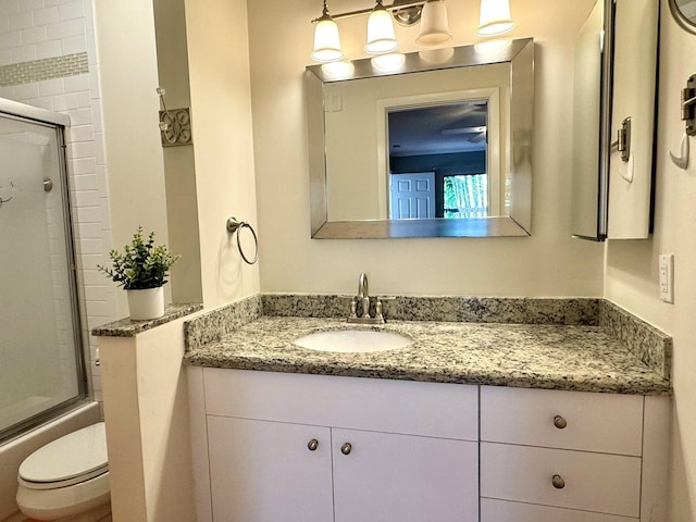 full bathroom with toilet, vanity, and shower / bath combination with glass door