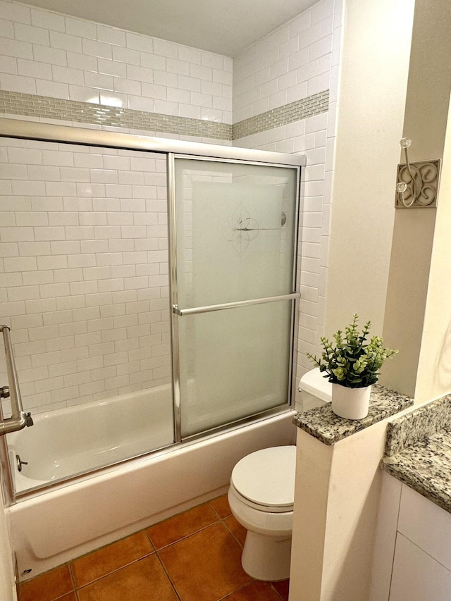 full bathroom with shower / bath combination with glass door, tile patterned flooring, toilet, and vanity