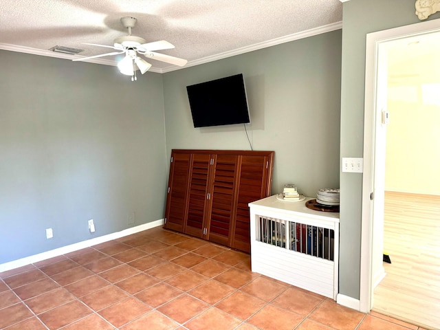 unfurnished bedroom with crown molding, tile patterned flooring, and a textured ceiling