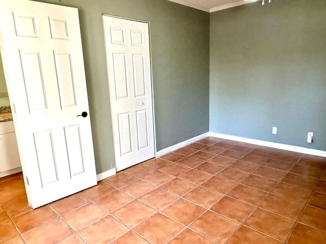 unfurnished bedroom featuring ornamental molding and tile patterned floors