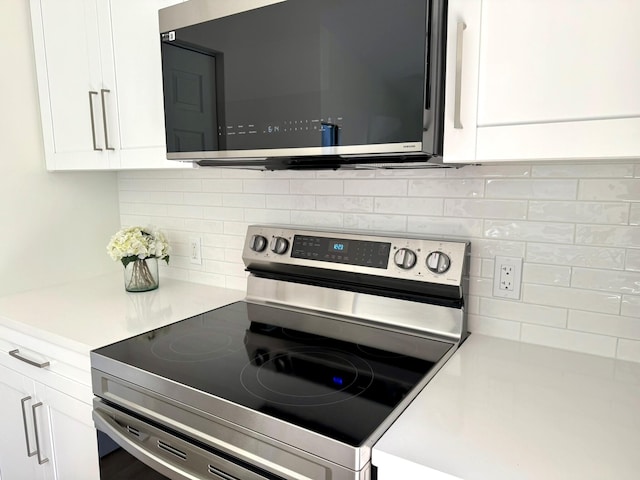 kitchen with stainless steel range with electric stovetop, white cabinetry, and tasteful backsplash