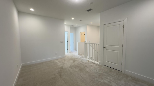 unfurnished room featuring light colored carpet