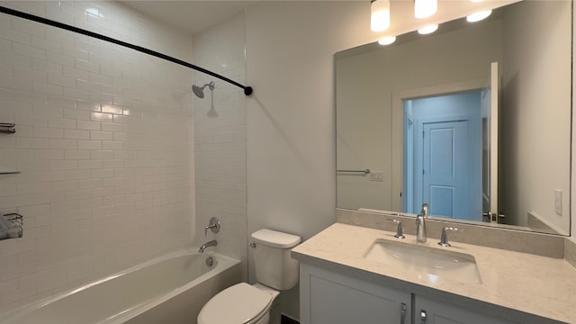 full bathroom featuring tiled shower / bath, vanity, and toilet