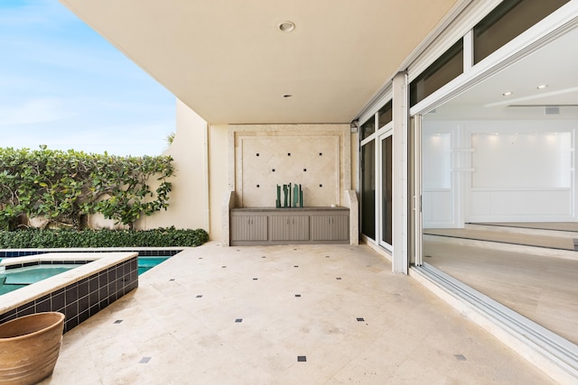 view of patio / terrace featuring a swimming pool with hot tub