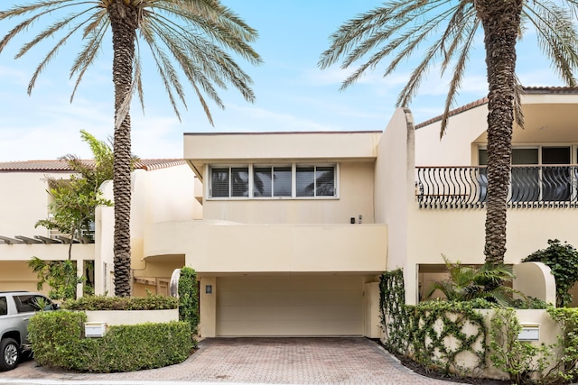 view of front of property featuring a balcony and a garage