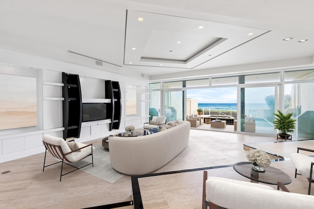 living room featuring expansive windows and a tray ceiling