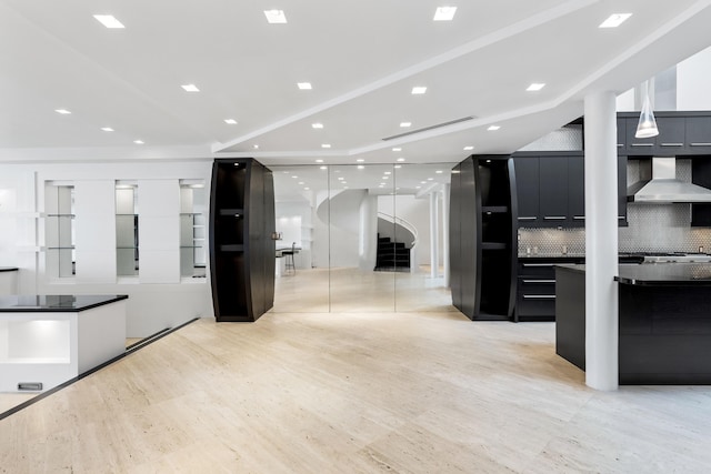 kitchen with decorative backsplash and wall chimney range hood