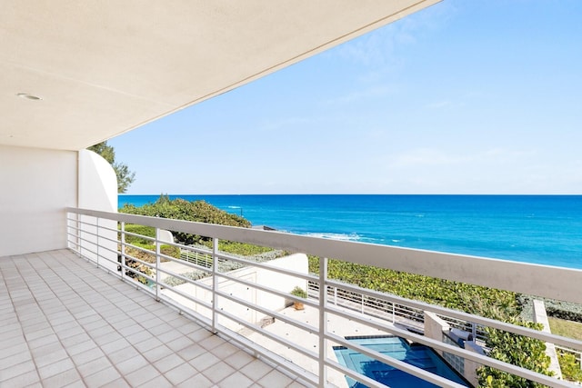 balcony with a water view and a view of the beach