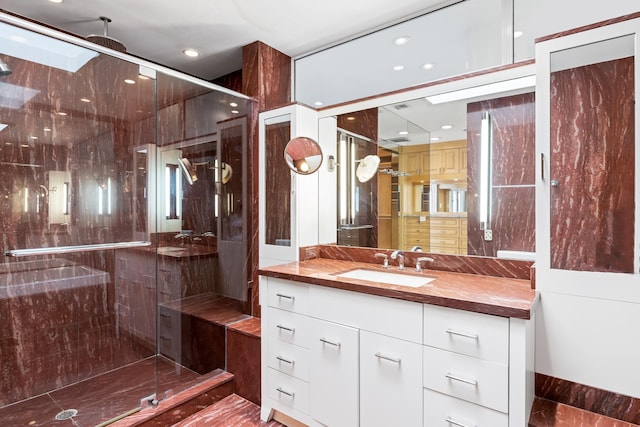 bathroom featuring vanity, a skylight, and walk in shower