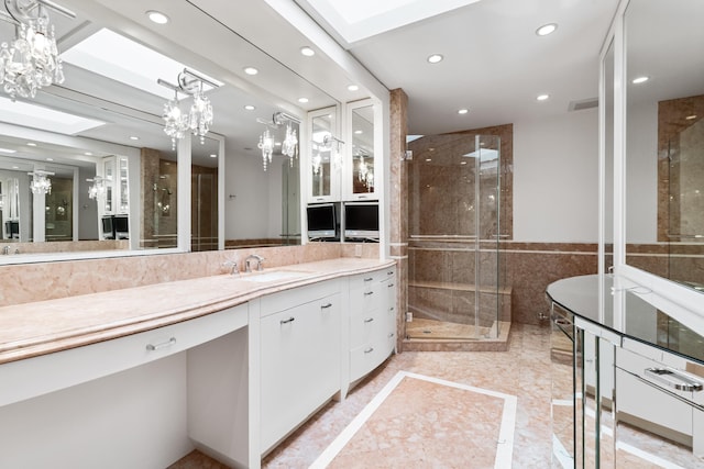 bathroom with a skylight, vanity, a chandelier, and walk in shower