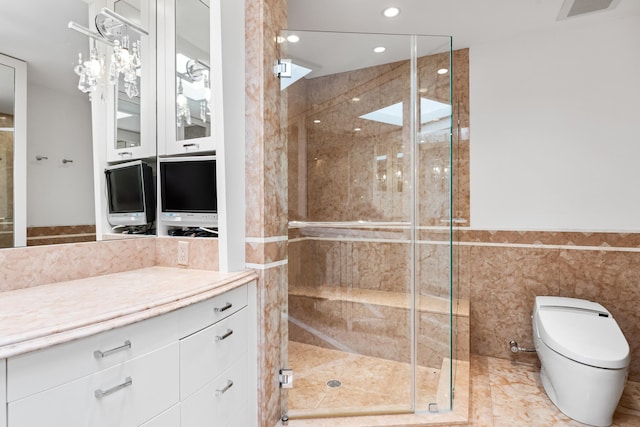 bathroom with vanity, toilet, tile walls, and walk in shower