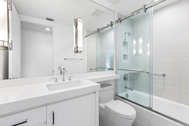 full bathroom with combined bath / shower with glass door, toilet, and vanity