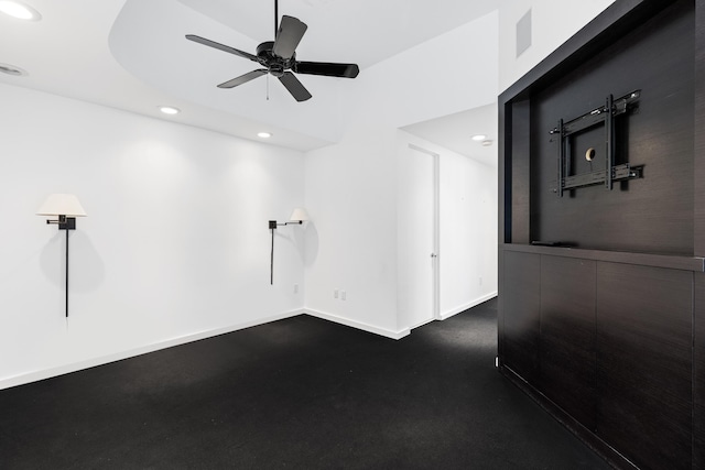 unfurnished room with ceiling fan and a tray ceiling