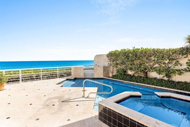 view of pool featuring an in ground hot tub and a water view