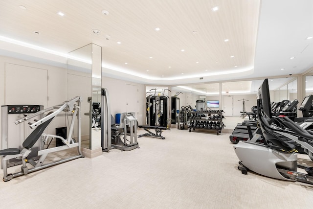 workout area with carpet, a raised ceiling, and wooden ceiling