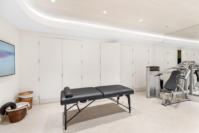 workout area with a tray ceiling