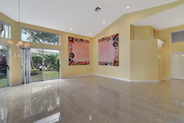 empty room featuring a towering ceiling and a chandelier