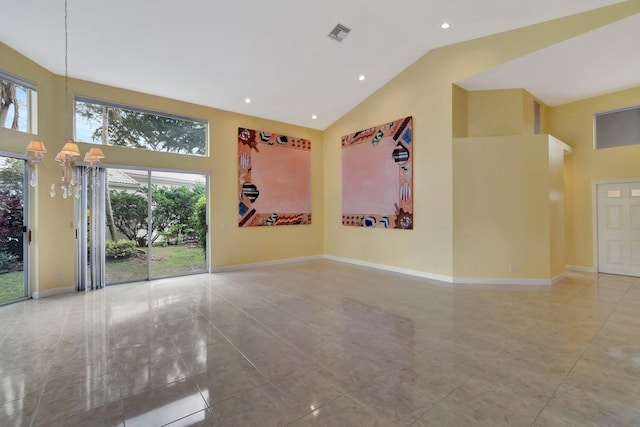 tiled empty room with high vaulted ceiling, visible vents, and baseboards