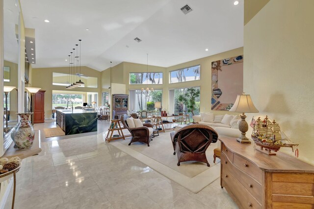 living room featuring a notable chandelier and high vaulted ceiling