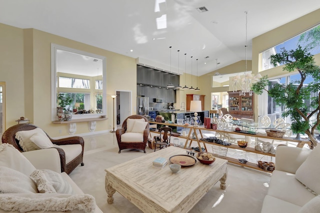 living room with high vaulted ceiling, visible vents, and light colored carpet