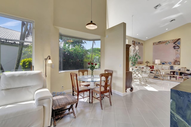 dining space with light tile patterned flooring and high vaulted ceiling