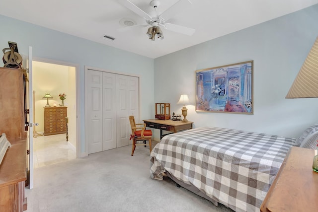 bedroom featuring ceiling fan, visible vents, a closet, and light colored carpet