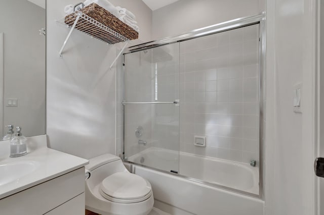 full bath featuring vanity, toilet, and bath / shower combo with glass door