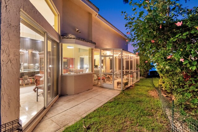 back of property with a lawn and stucco siding