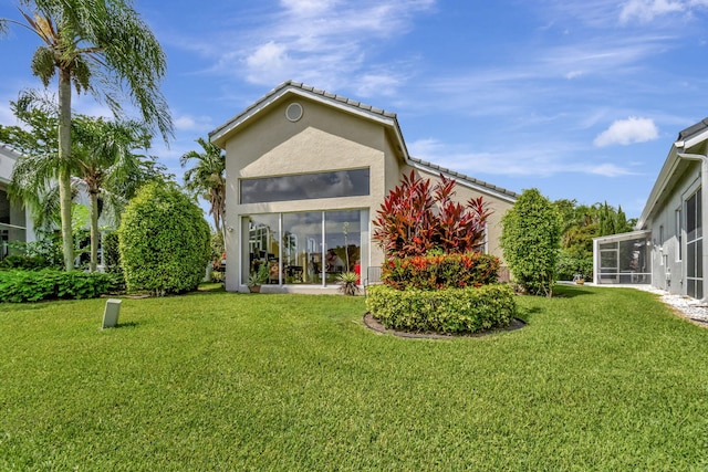 back of house with a sunroom and a lawn