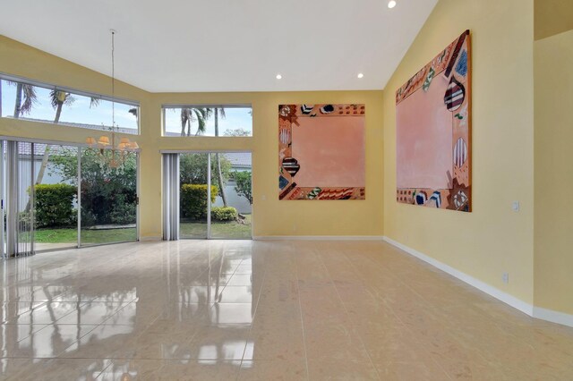 corridor featuring light tile patterned floors and high vaulted ceiling