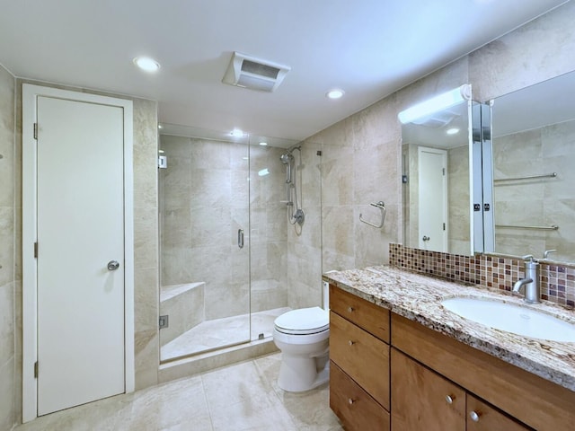 bathroom featuring tile patterned floors, toilet, decorative backsplash, a shower with door, and vanity