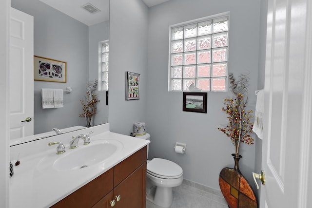 bathroom with tile patterned flooring, vanity, and toilet