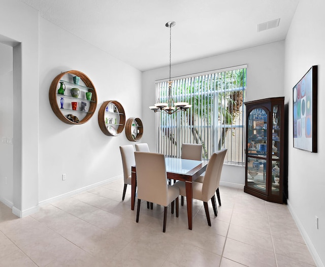 tiled dining room featuring a chandelier