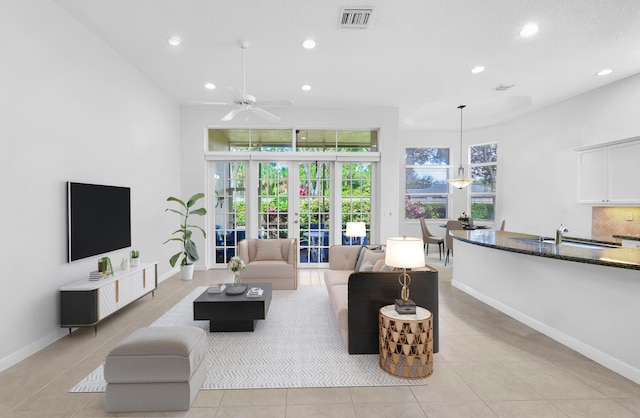 tiled living room with ceiling fan, french doors, and sink