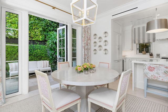 dining room featuring a notable chandelier, light tile patterned flooring, and crown molding