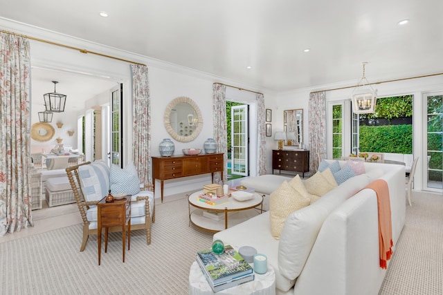 carpeted living room with ornamental molding and a chandelier