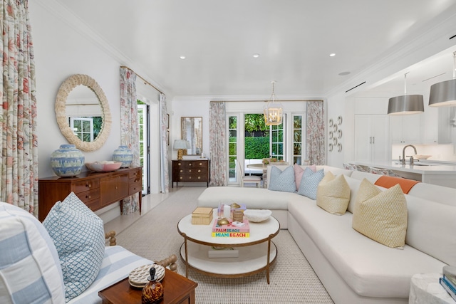 living room with a chandelier, crown molding, and sink