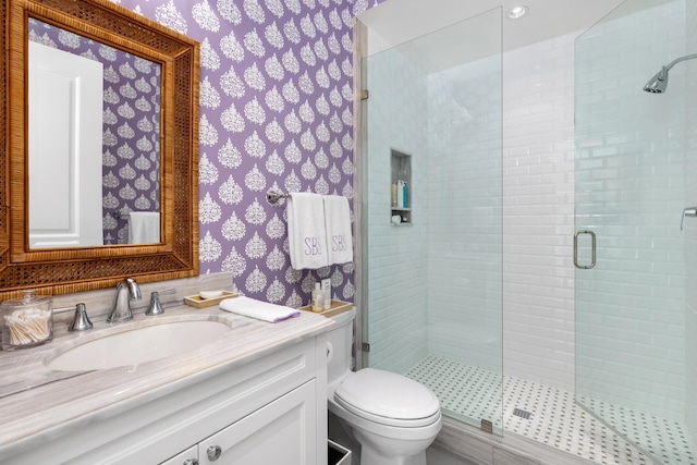 bathroom with a shower with door, vanity, and toilet