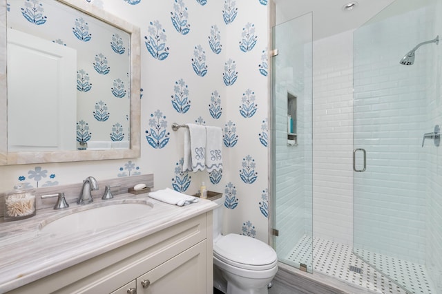 bathroom featuring vanity, an enclosed shower, and toilet