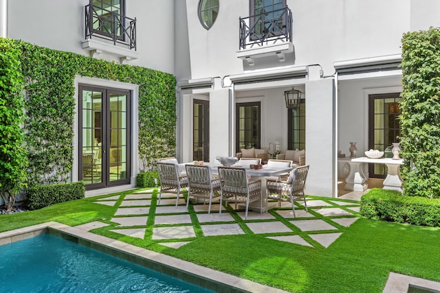 rear view of property featuring outdoor lounge area, french doors, and a patio