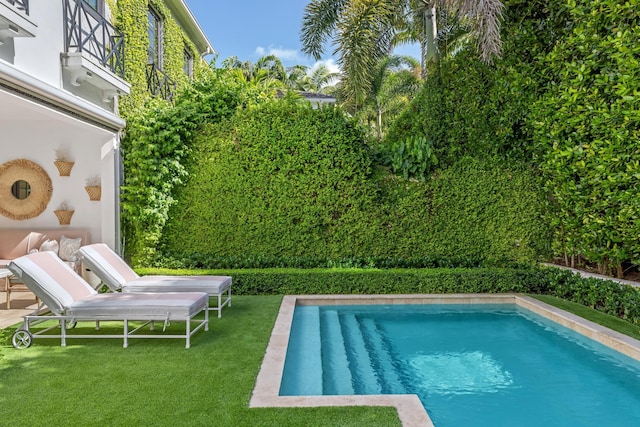 view of pool featuring a lawn