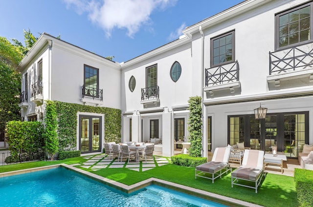 back of house with french doors, a balcony, and a patio